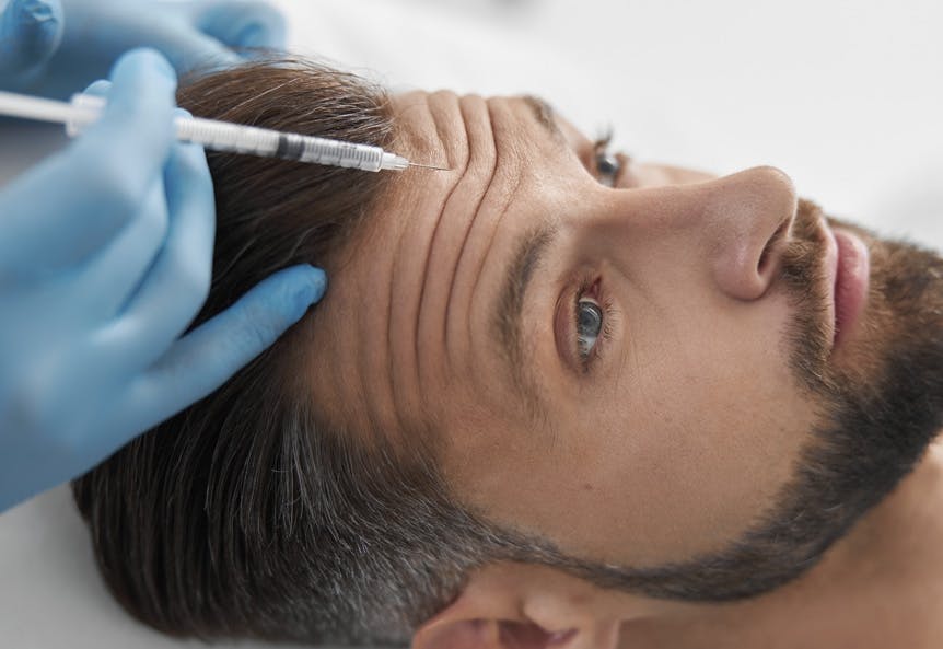 Man having botox injection in forehead