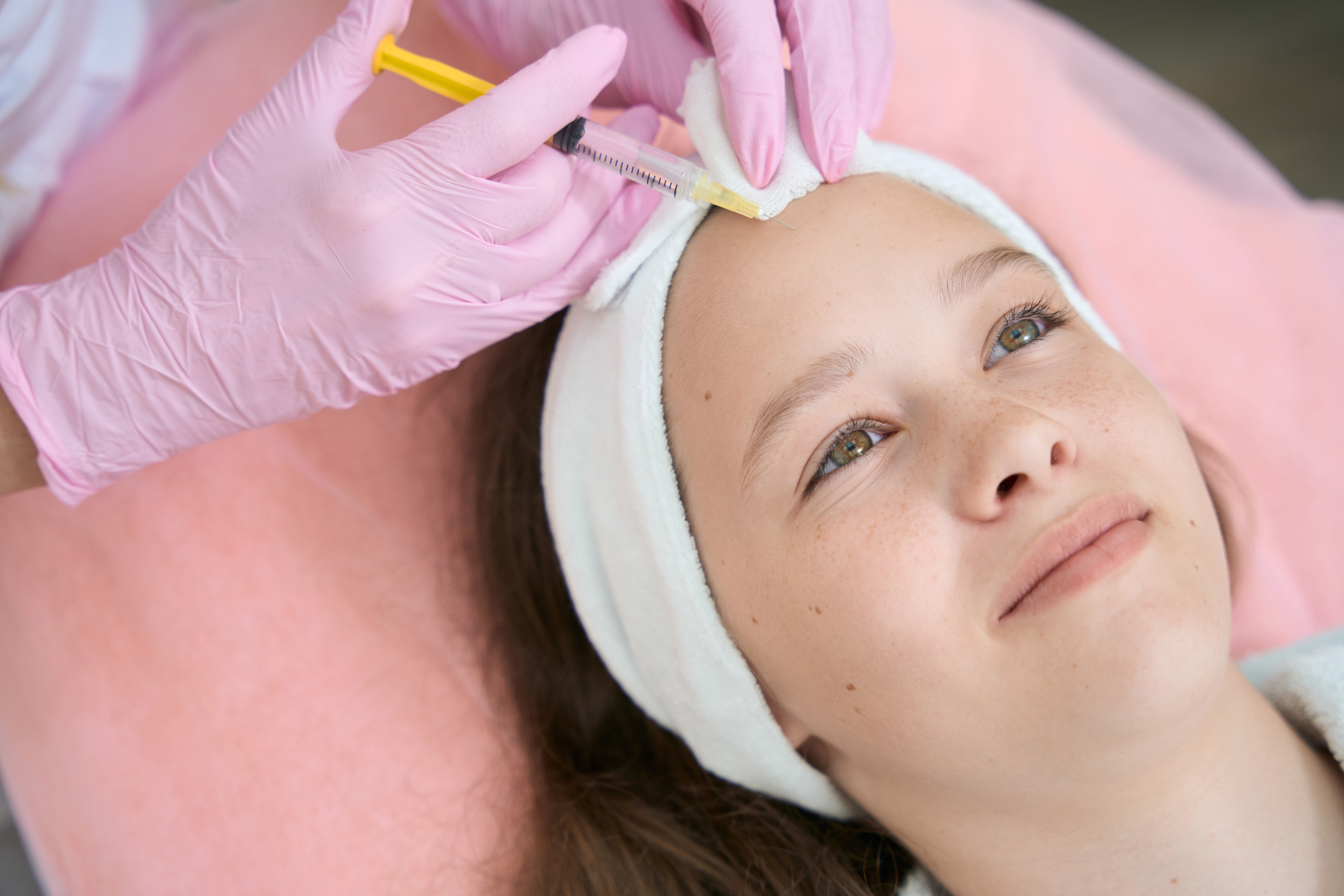 Under age girl receiving cosmetic treatment by beauty therapist
