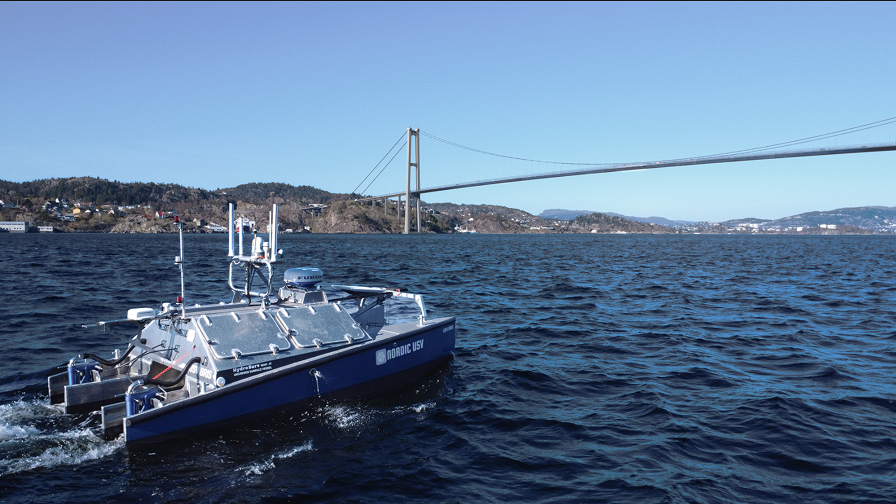 En ubemannet båt som beveger som mot en stor bro.