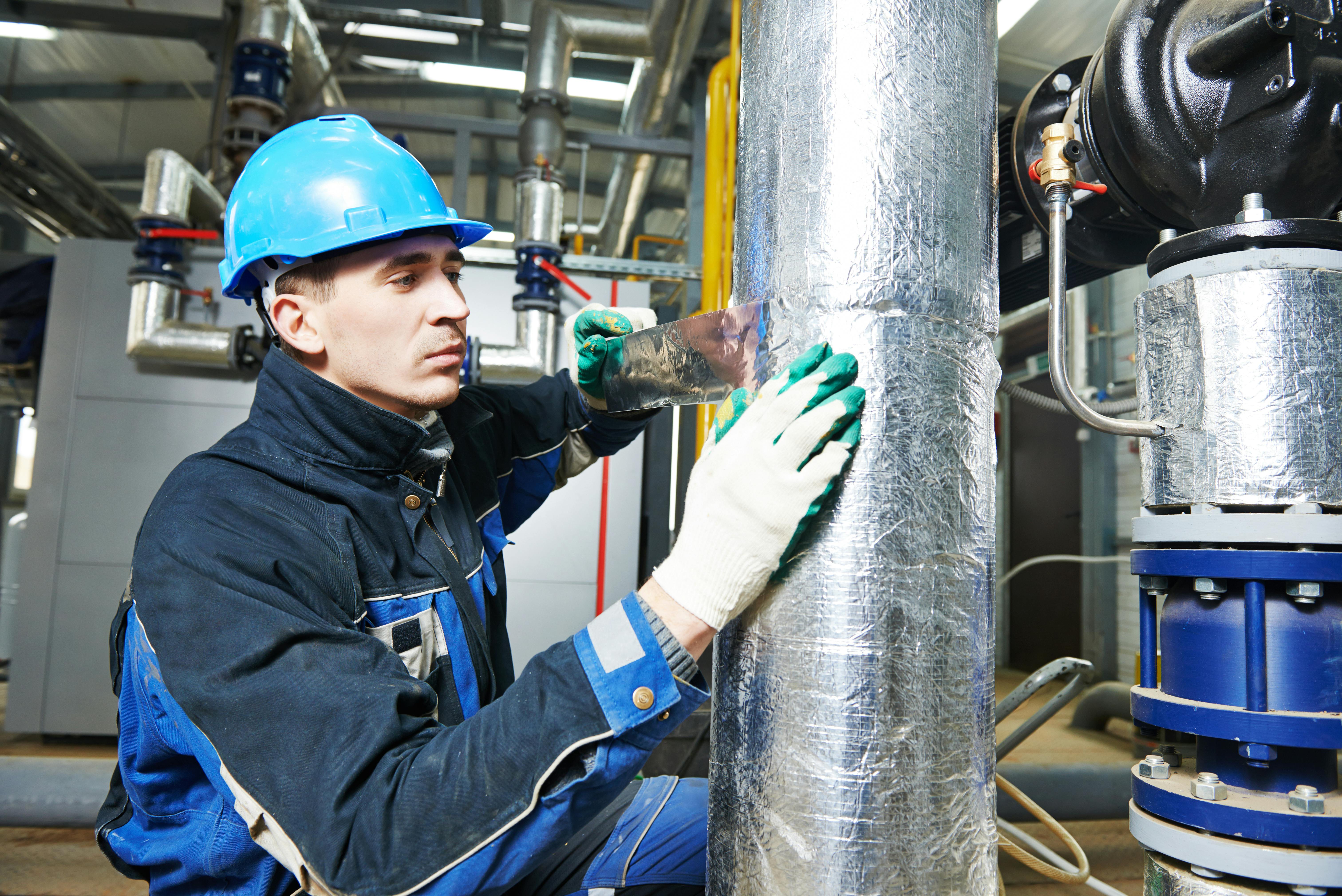 Trabajador con casco azul aplicando aislamiento