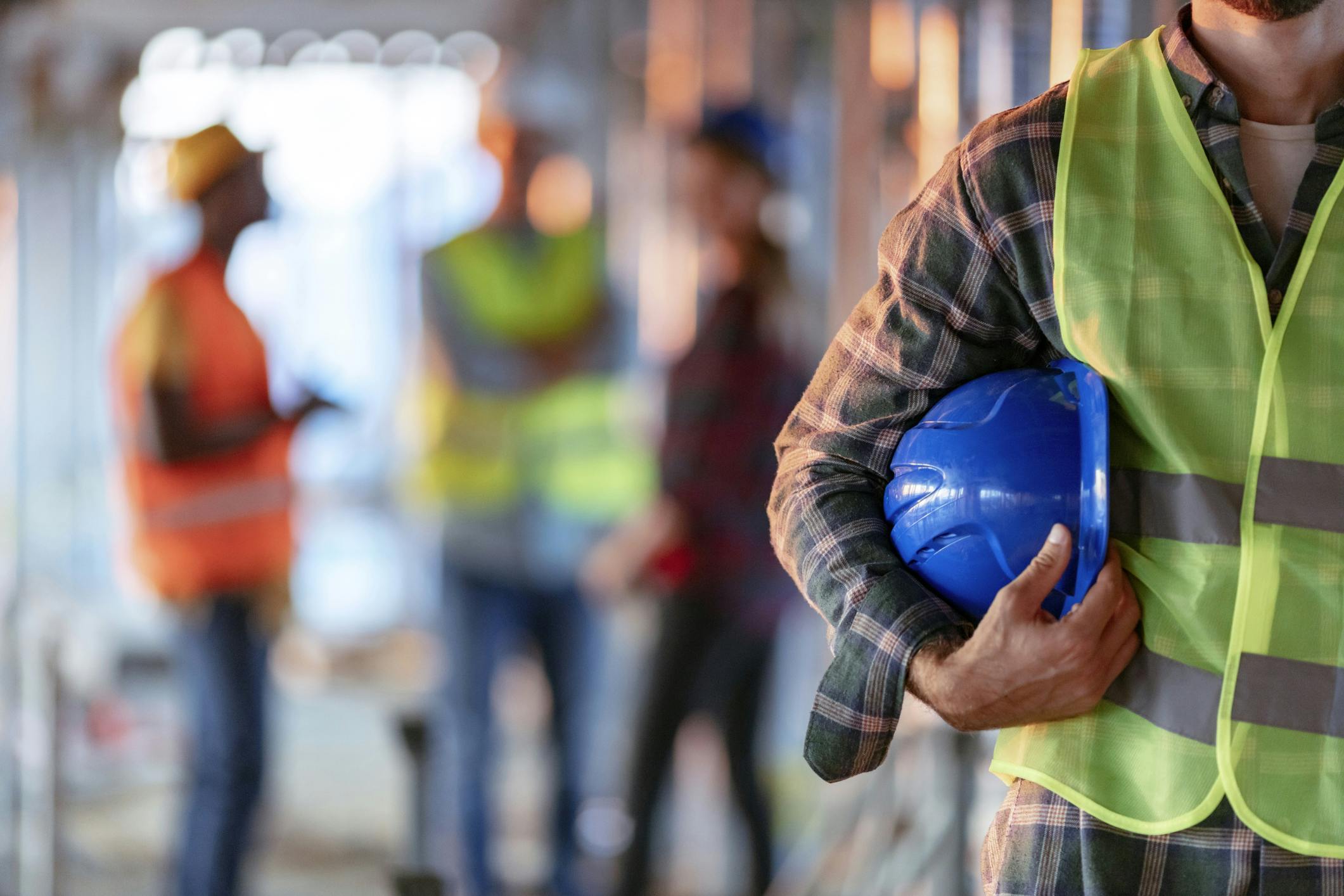 An expert worker holding a blue helmet