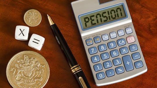 Calculator, pen and coins to calculate pension