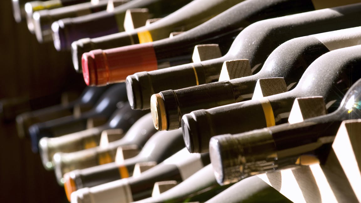 Wine bottles on a rack - the outcome of a good day's wine investing