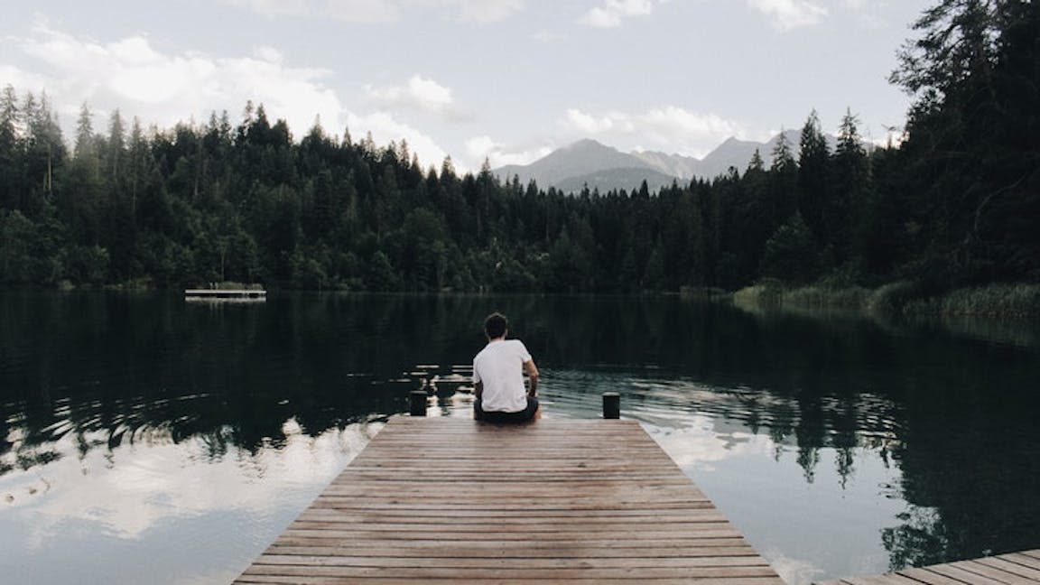 man sits on pier