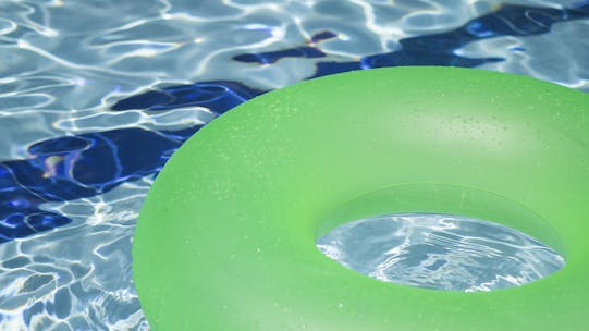 Green round lilo in swimming pool