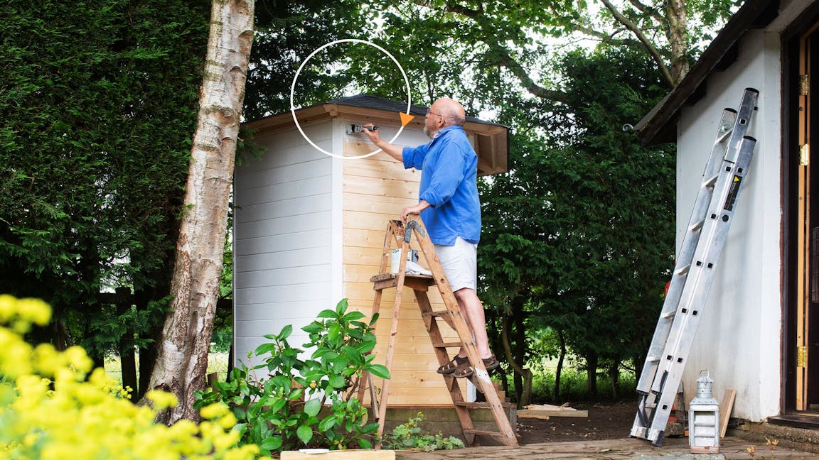 Pensioner painting a shed