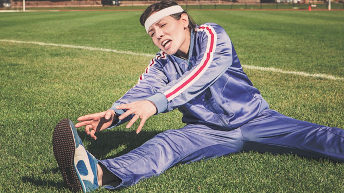 Woman stretching in park in exercise clothes