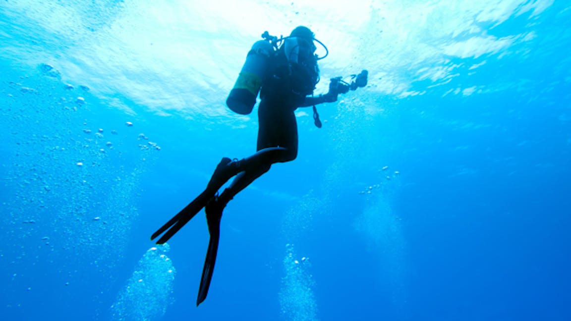 Image of scuba diver underwater rising towards surface