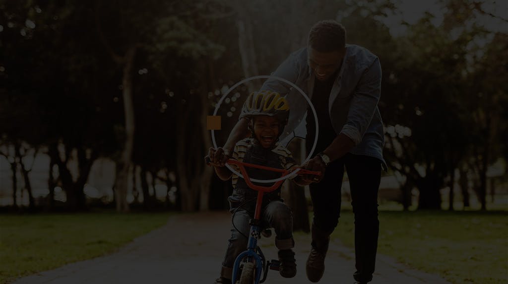 Father teaching son to ride a bicycle