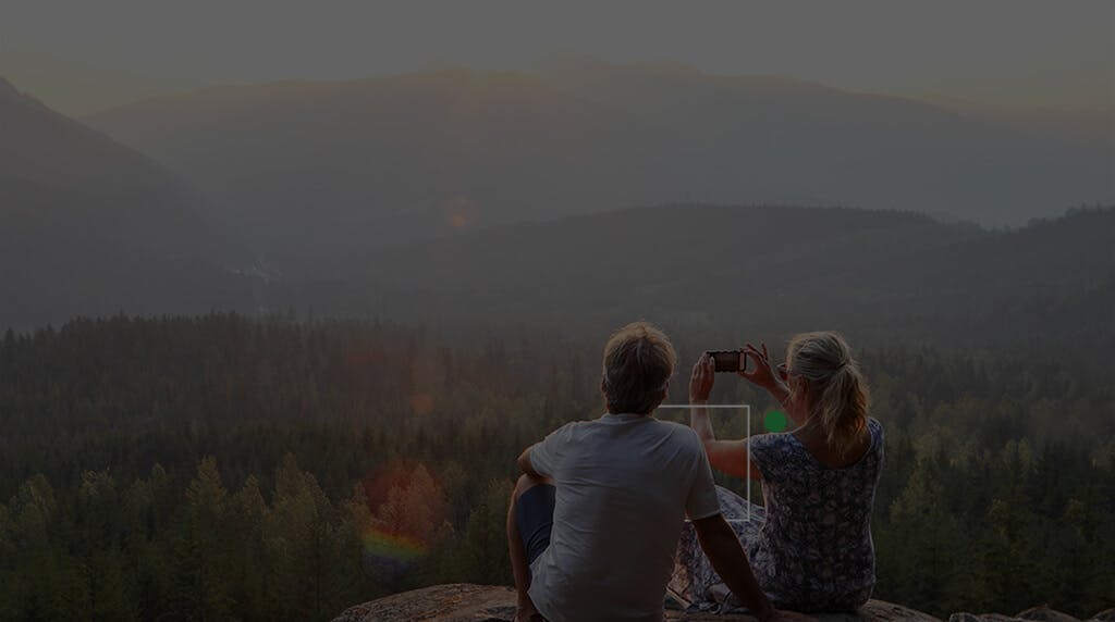 Couple enjoying a mountains view, taking pictures