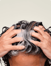 Two hands massaging Root Purifier Shampoo into scalp and hair.