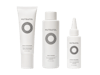 White bottles of Nutrafol Exfoliating Mask, Root Purifier Shampoo, and Stress Reliever Essence.