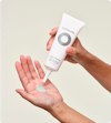 Person putting a dollop of Nutrafol Exfoliating Mask—a light green gel with exfoliating Jojoba Esters—into hands.