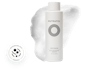 White bottle of Nutrafol Root Purifier Scalp Microbiome Shampoo with white, foamy shampoo behind the bottle.