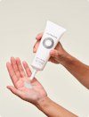 Person putting a dollop of Nutrafol Exfoliating Mask—a light green gel with exfoliating Jojoba Esters—into hands.
