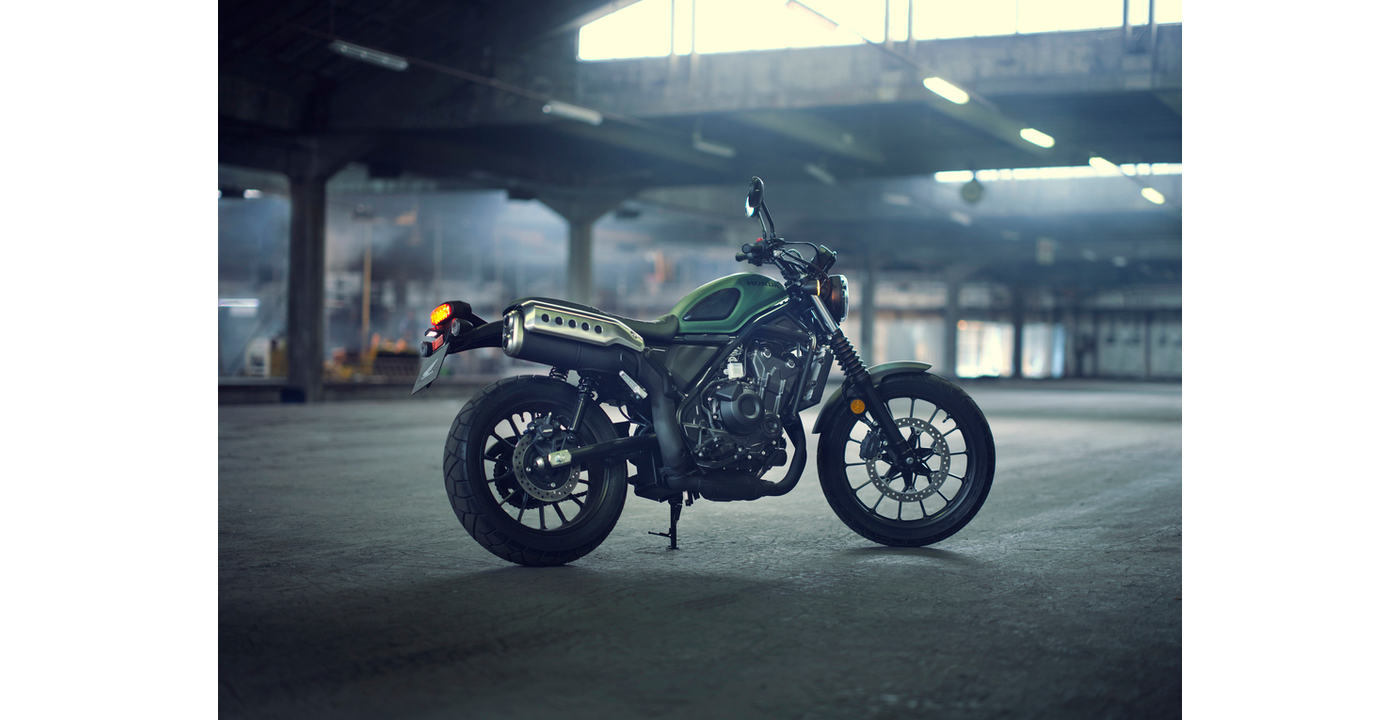 Grænt Honda CL500 á standara í reykmettuðu iðnaðarhúsnæði 