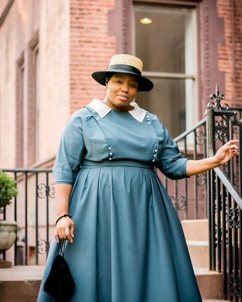Cheyney McKnight dressed in early 20th century period clothing standing on stairs outside
