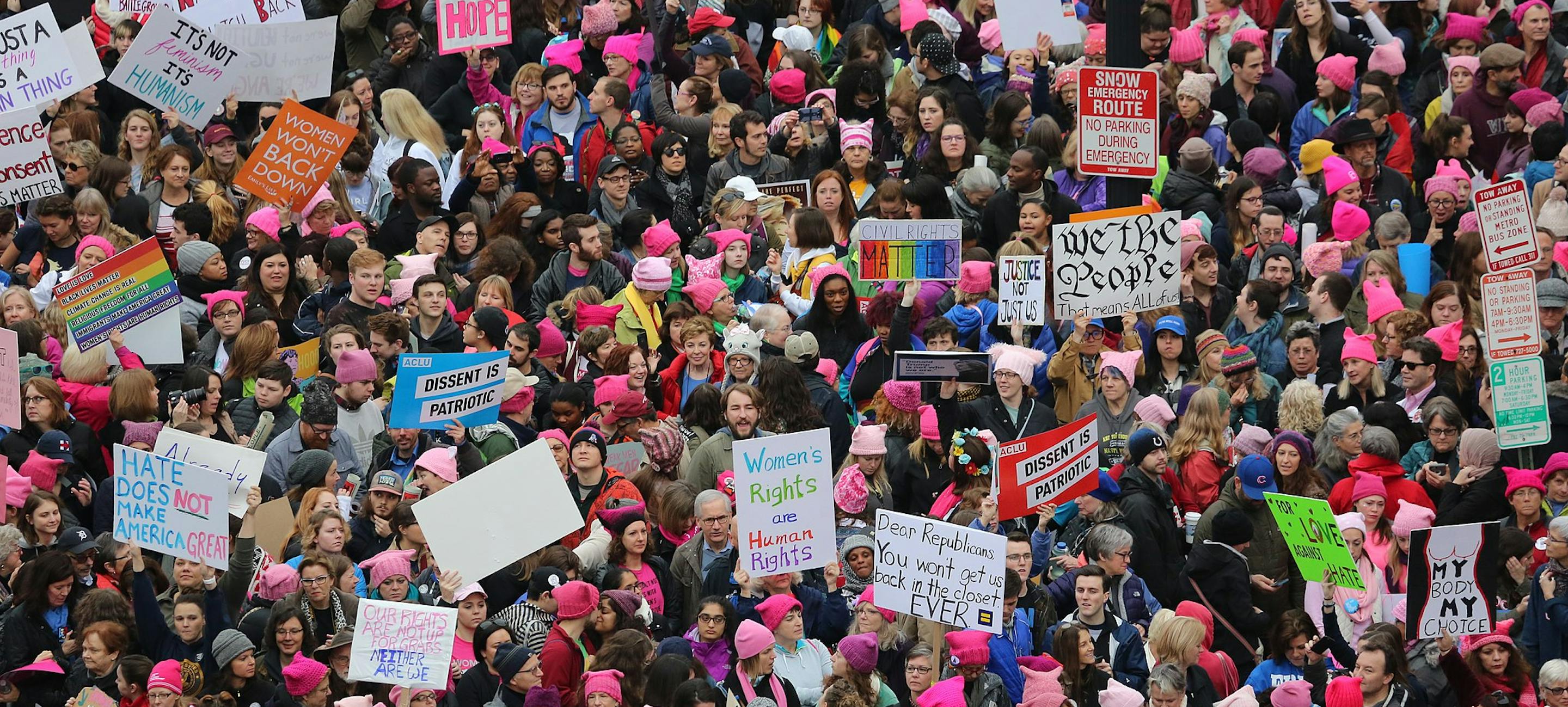a massive crowd at the 2017 women's march in washington DC holding an array of signs. 