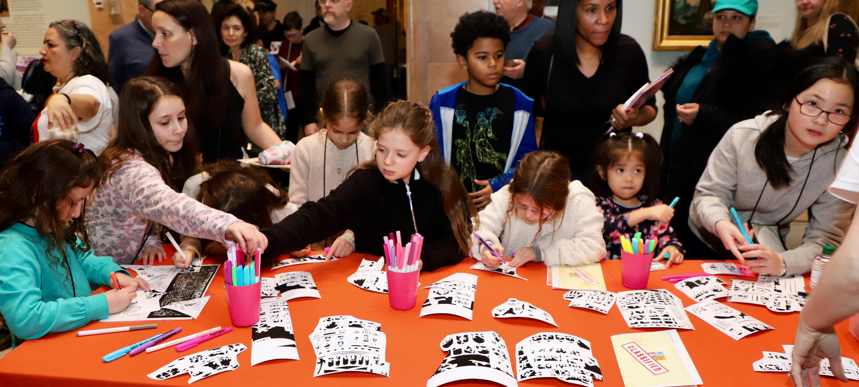 a crowd of youngsters complete a craft at a previous NYHS family day