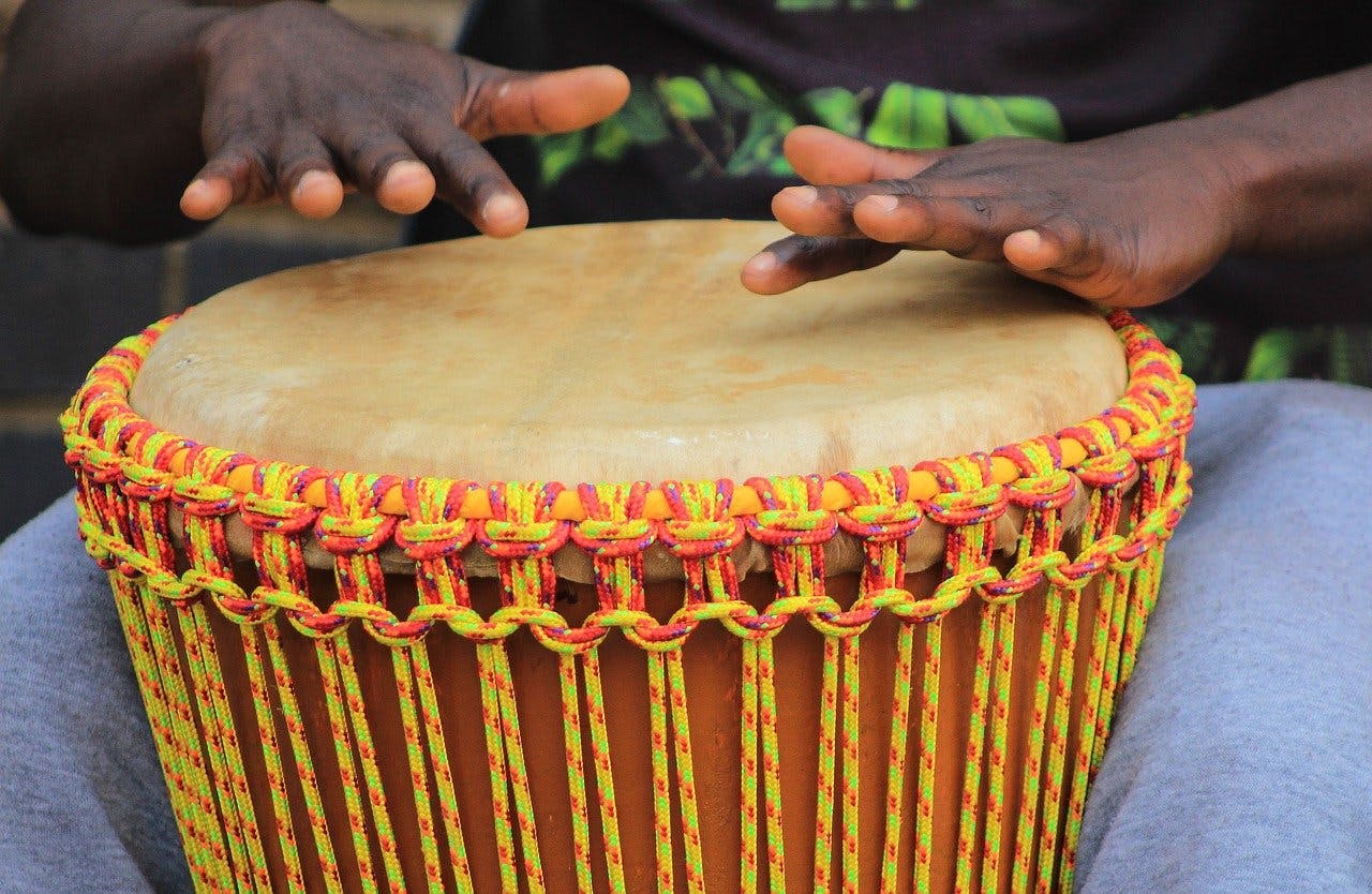 Black hands playing a West African drum