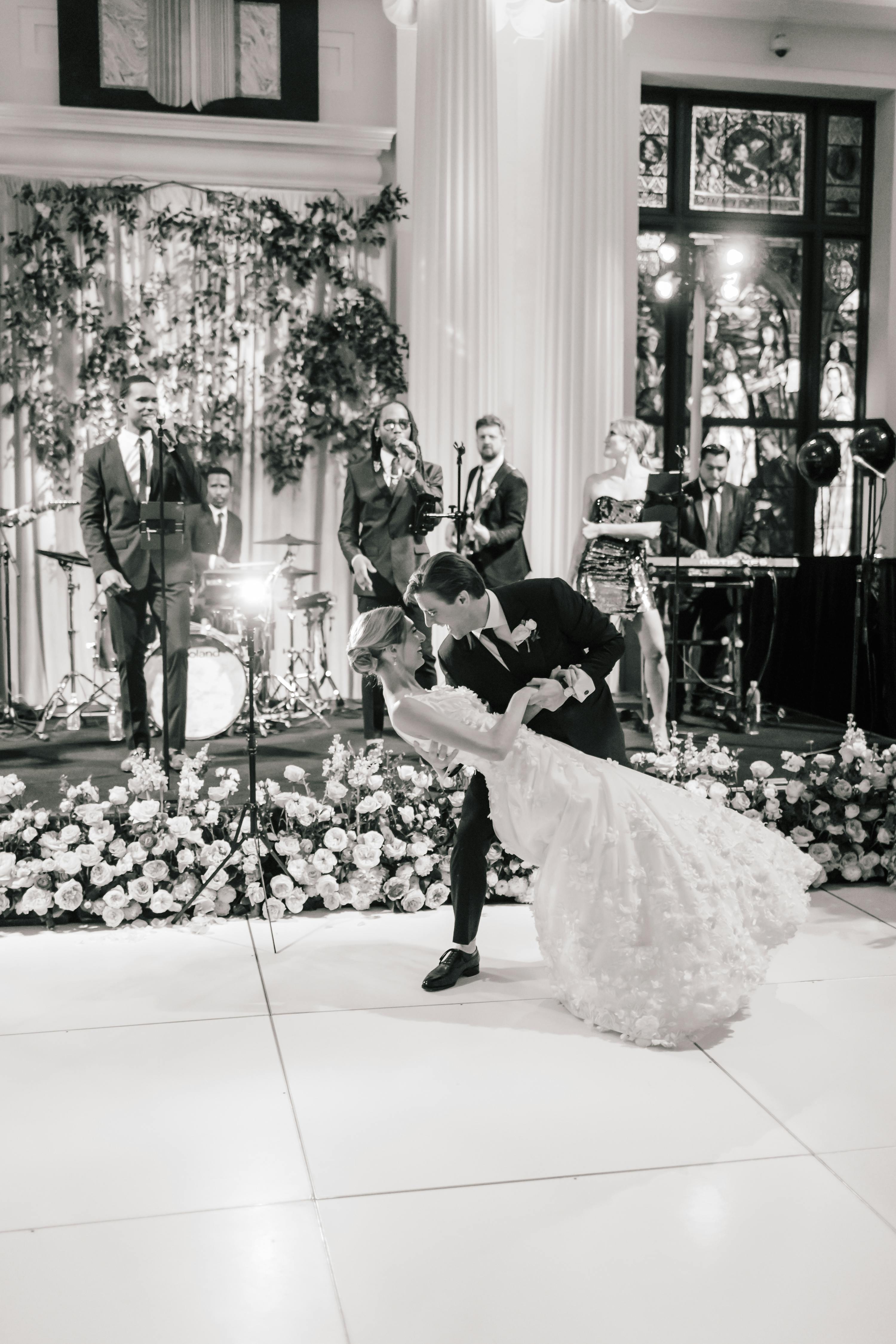 a black and white image of a bride and groom dancing on a floor in the Library during a wedding reception