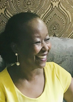 Head short of Farah Jasmine Griffin sitting in an armchair and smiling