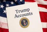 A sheet of paper titles "Trump Accounts" with presidential seal, with a backdrop of a US flag