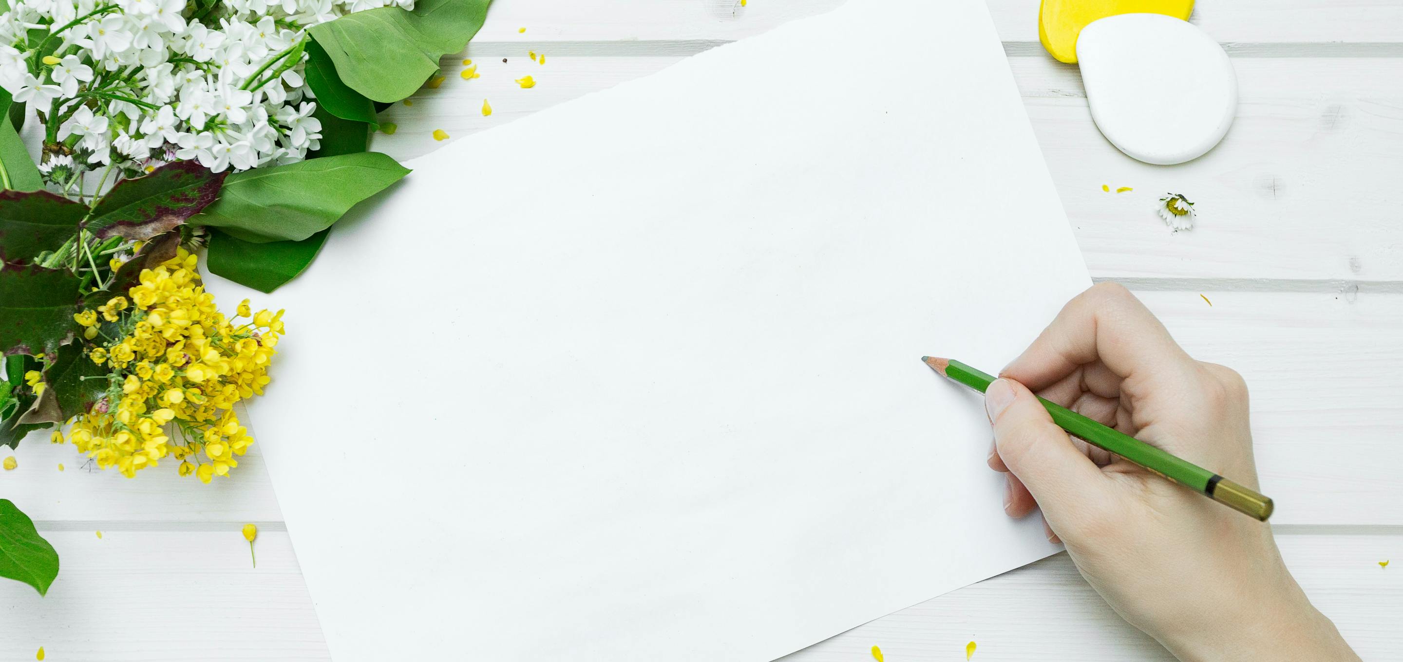 Flowers on a table, next to white paper