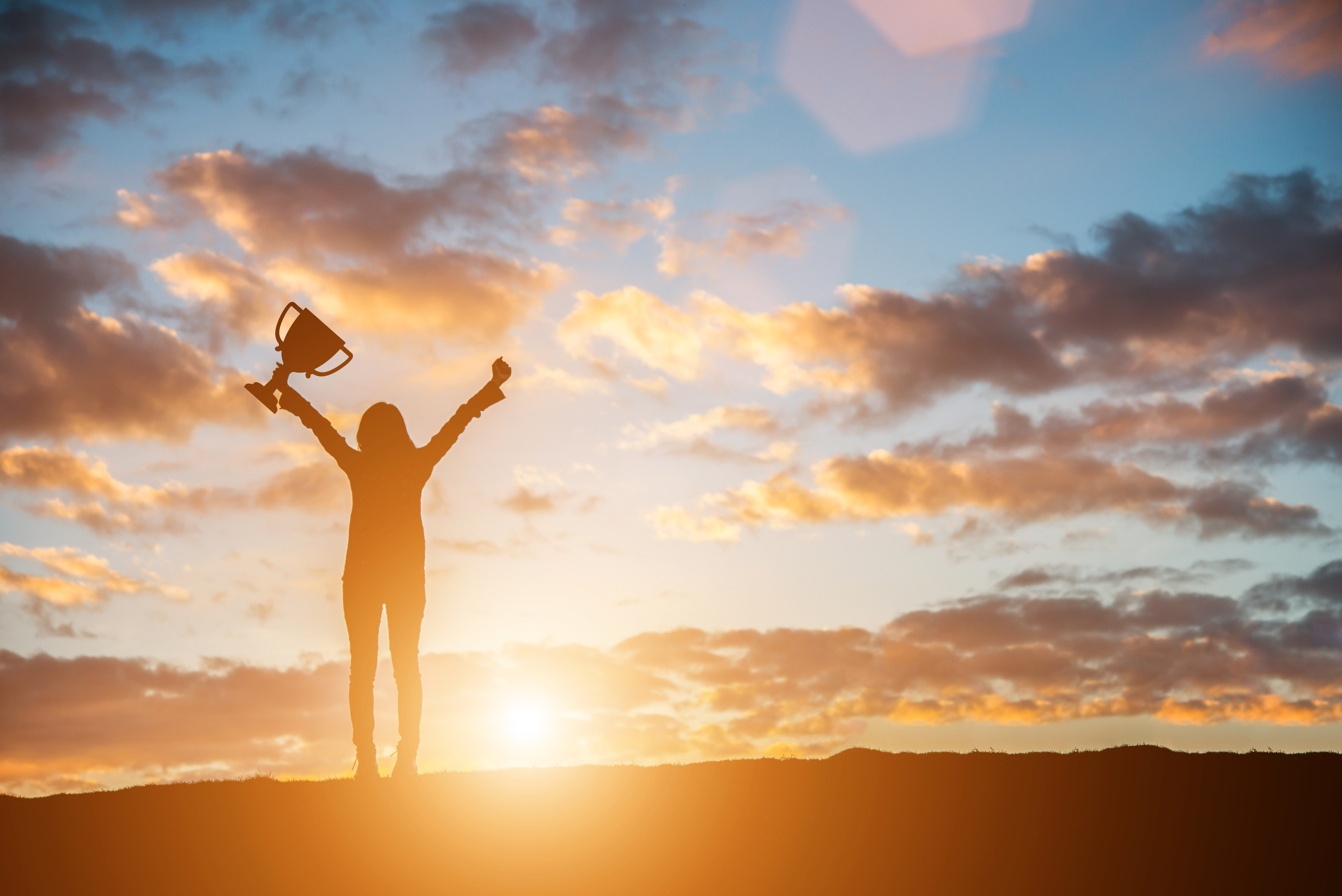 person raising arms in front of beautiful sky