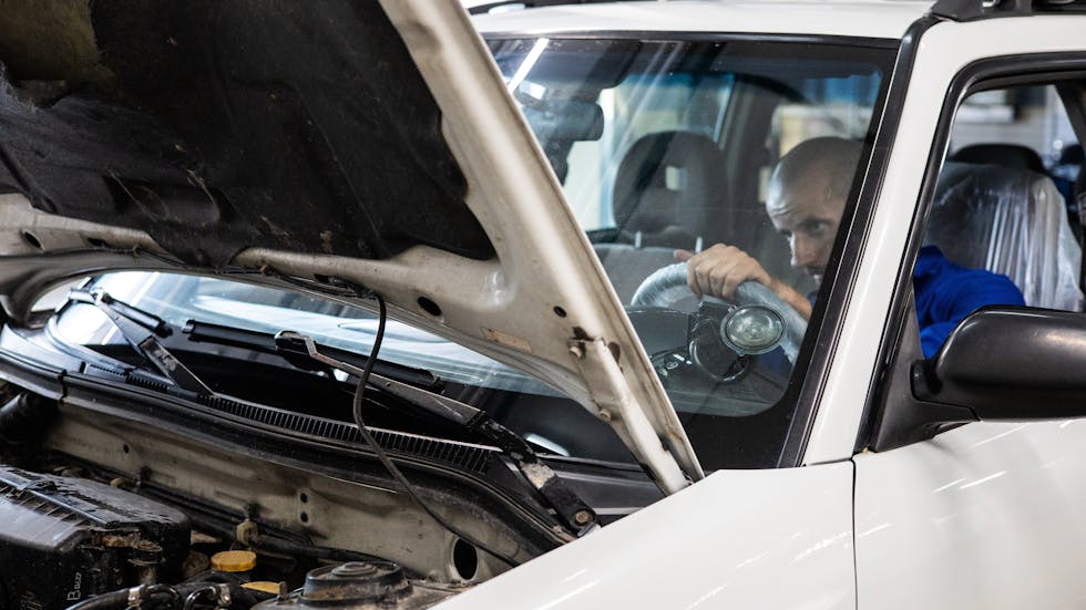 Mecánico revisando un coche reacondicionado