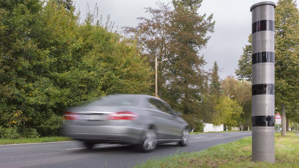 Coche circulando al lado de un radar de velocidad