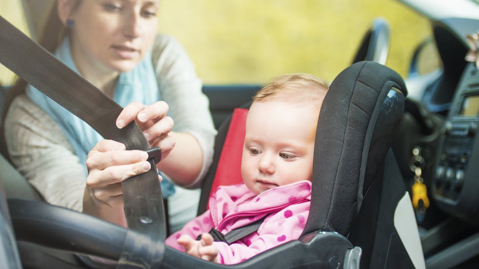 Bebé en el asiento del copiloto en su sistema de retención infantil