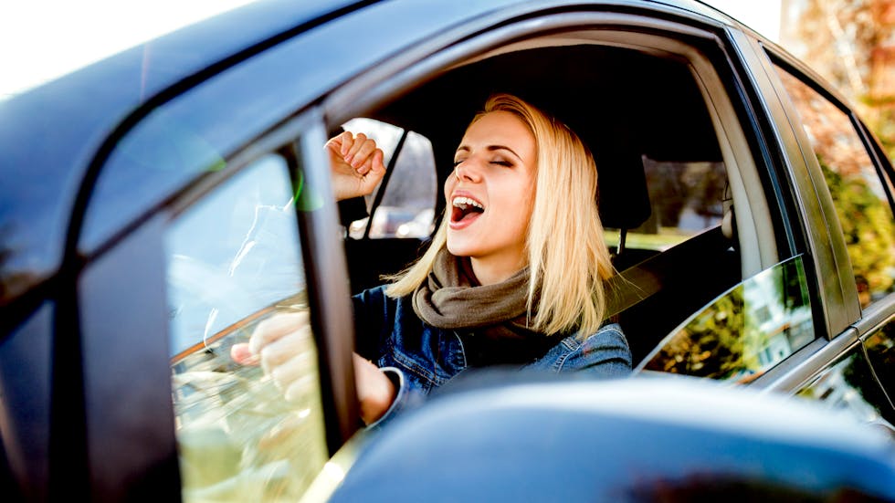 Mujer escuchando música al volante
