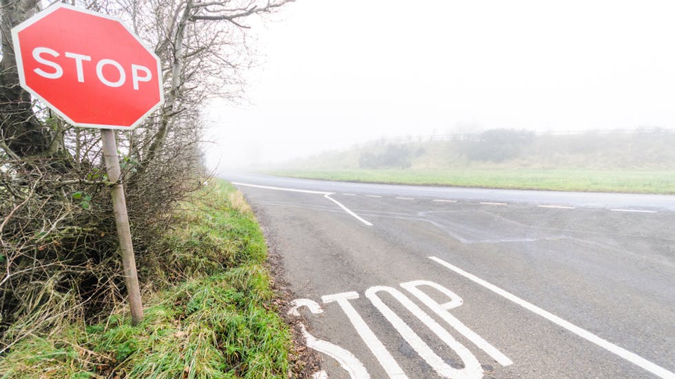 Señal de STOP en carretera con niebla