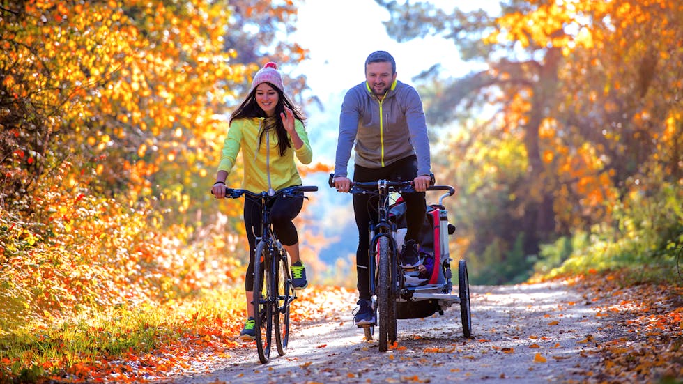 Padres con remolque de niño para bicicleta