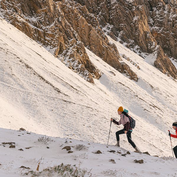 Two hikers trekking in the snow wearing the Katabatic Mid Waterproof hiking boots.