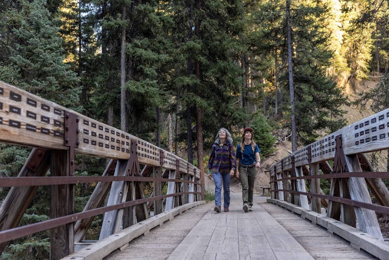 Two women crossing a wooden bridge in Oboz Ousel hiking boots