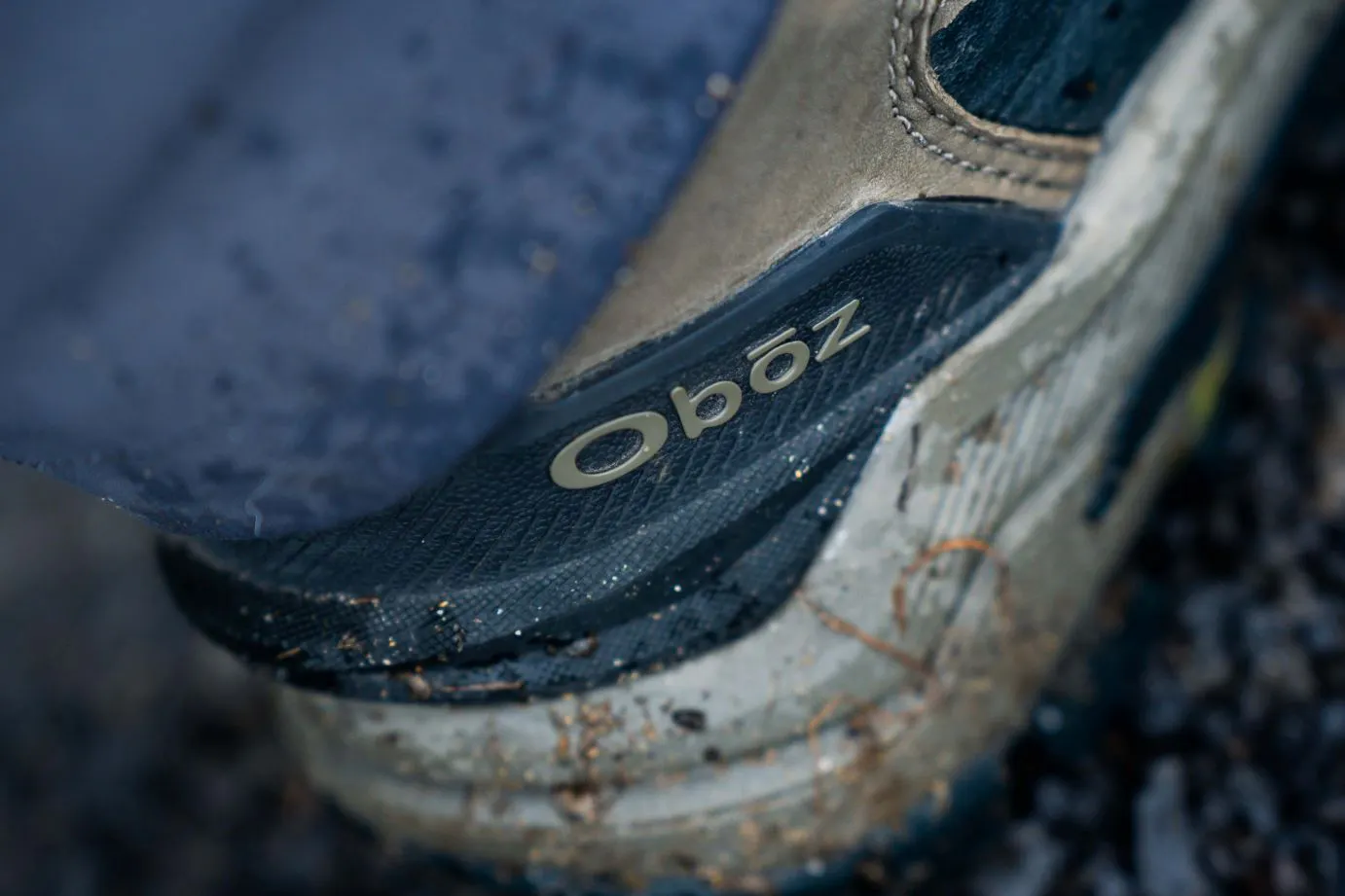 A pair of Oboz Bangtail winter shoes, muddy from trail adventures.