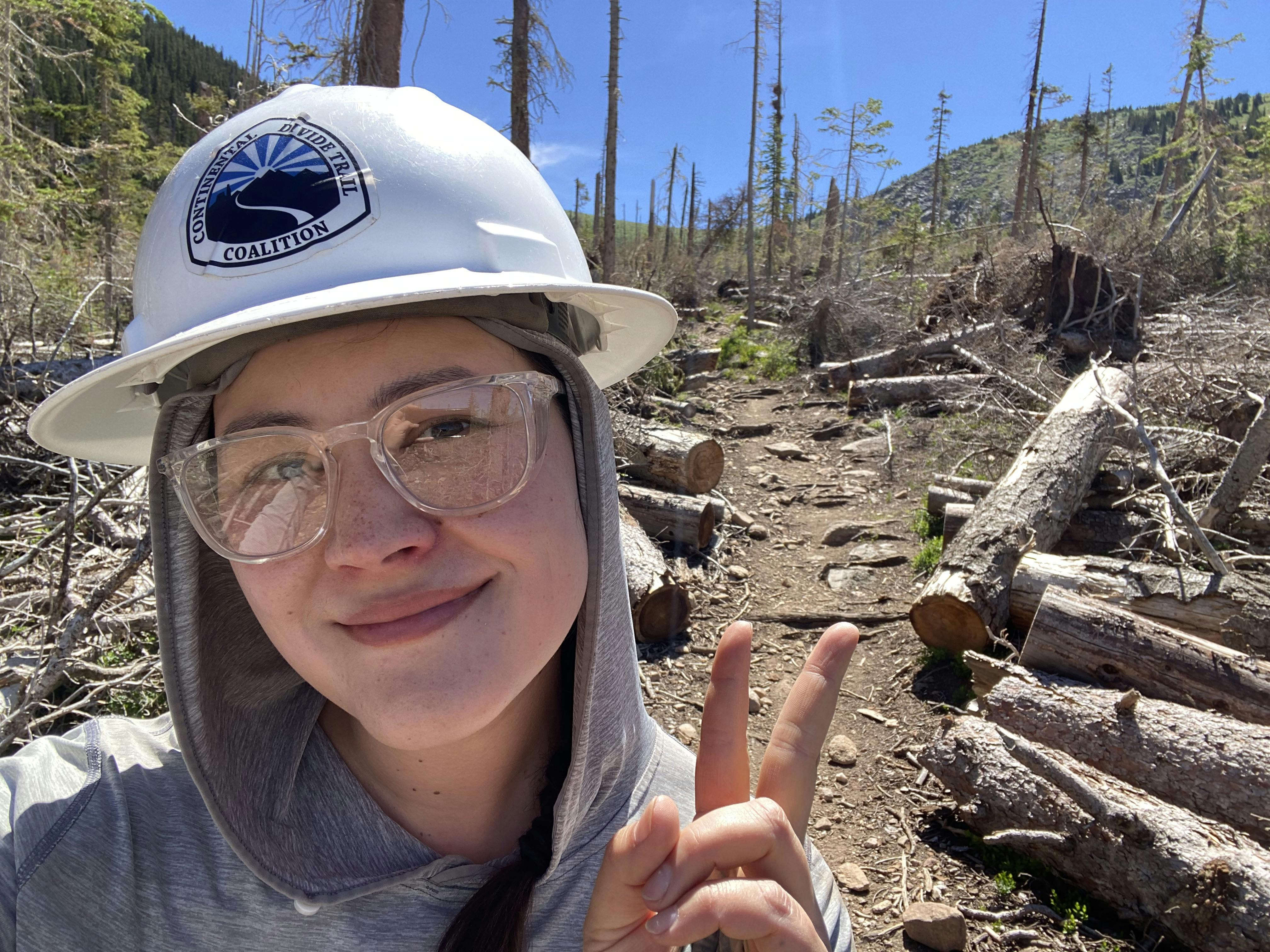 Trail maintenance worker showing her completed trail work.