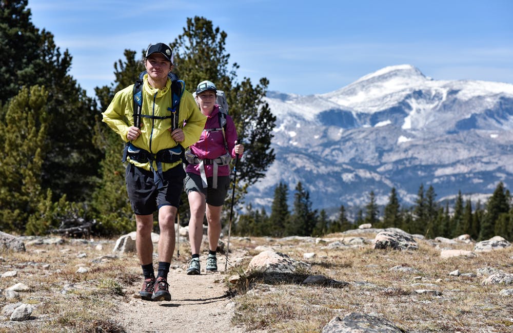 Two hikers in the Rocky Mountains backpacking with Oboz hiking boots.