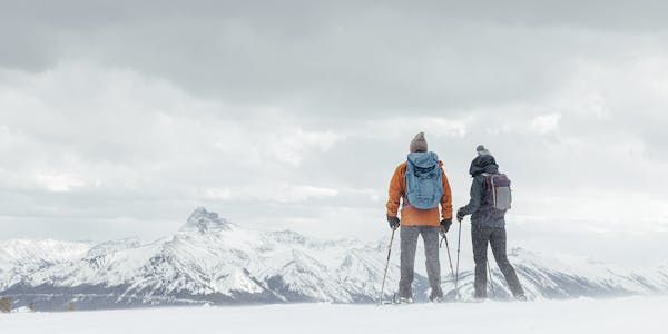 Two hikers wearing Oboz Bangtail boots on a snowy hike.