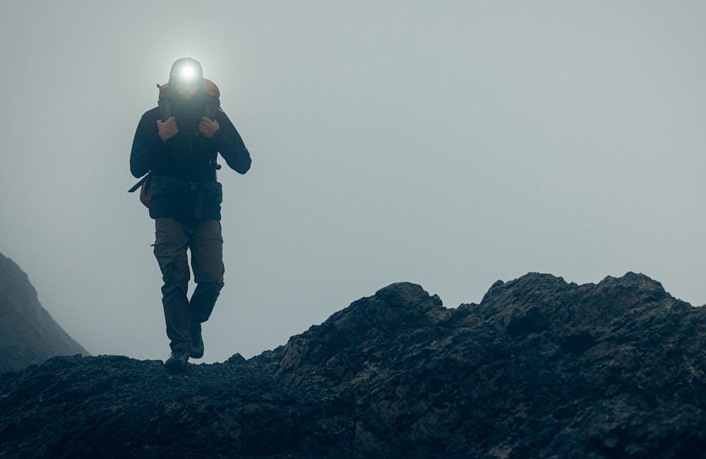 Lone hiker in dense fog on rocky mountain top in Oboz hiking boots