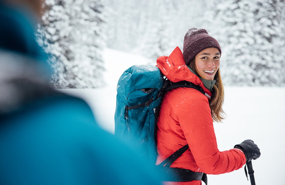 Woman smiling while on a snowy trail