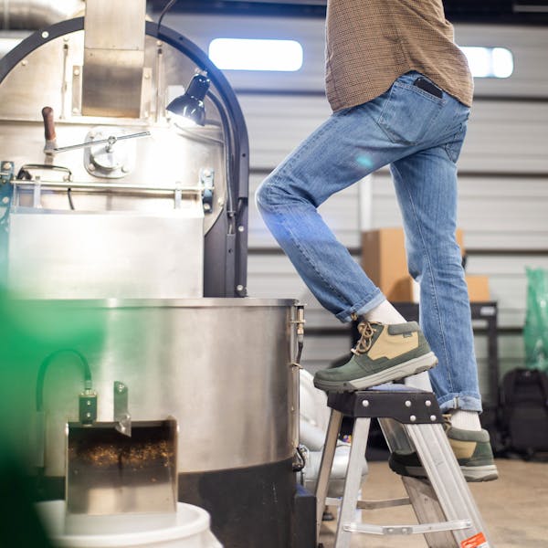 Man works with machinery in Oboz Burke Chukka casual shoes.