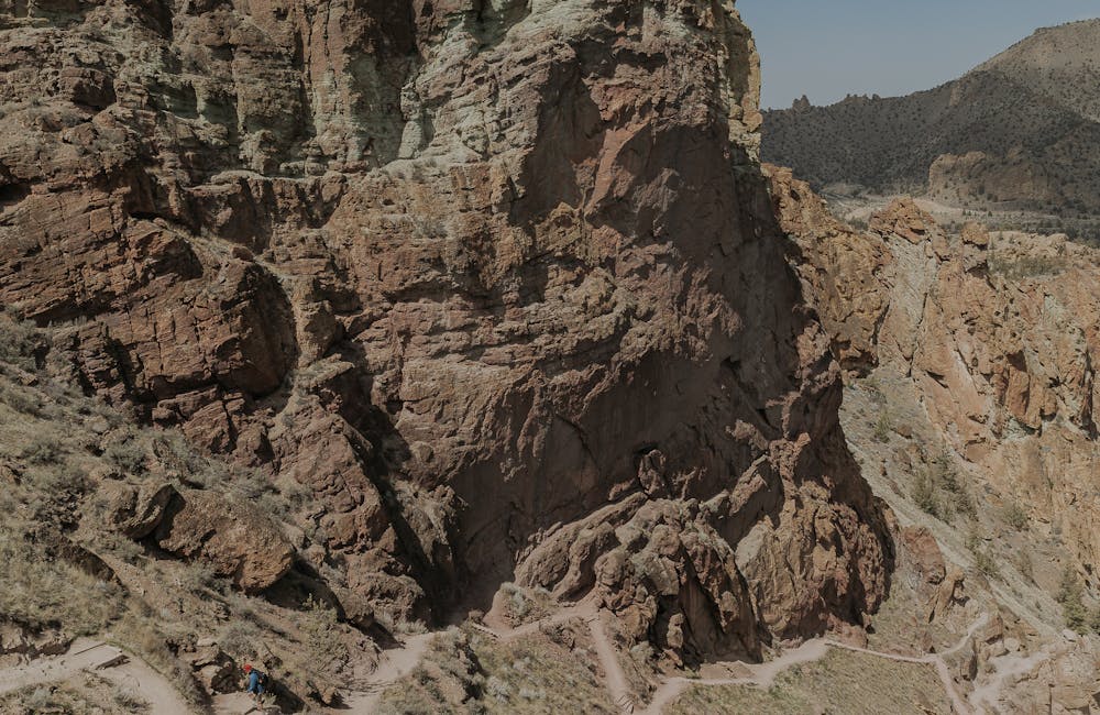 Trail views showing tall rock formations and hikers ascending a switchback trail 