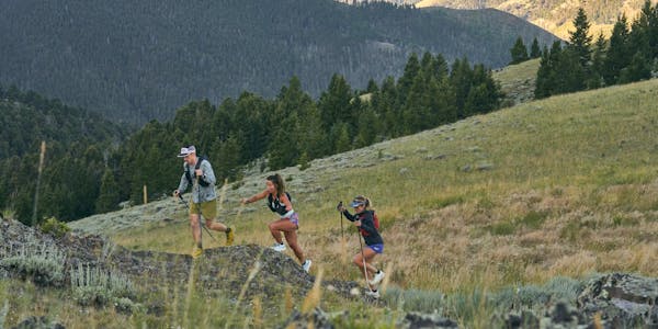 Group of hikers trail running up a mountain in Montana wearing Oboz trail shoes.