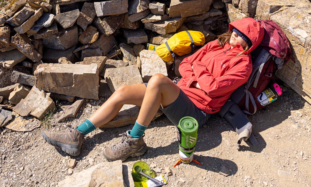 Backpacker taking a break on the trail in her Sawtooth X Mid hiking boots.