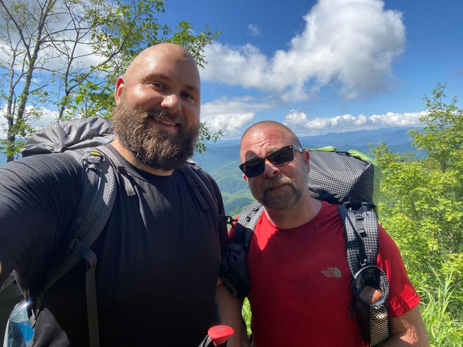 Two individuals backpacking the Smokies on a bright and sunny day