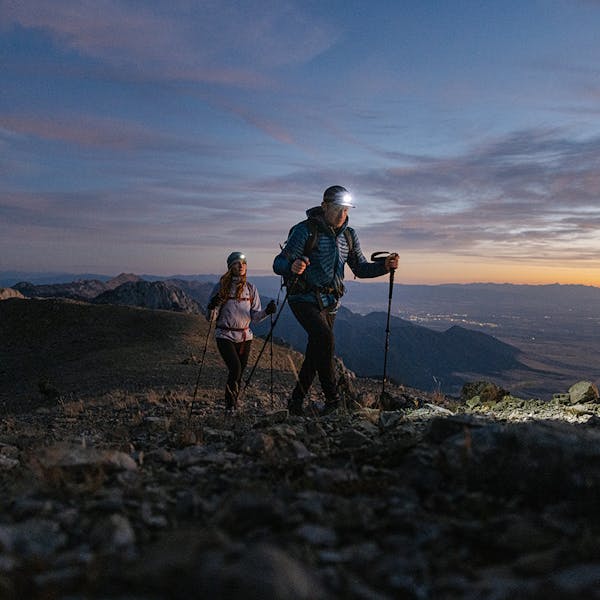 Two people hiking at dusk in the Katabatic Mid Hiking Boots.
