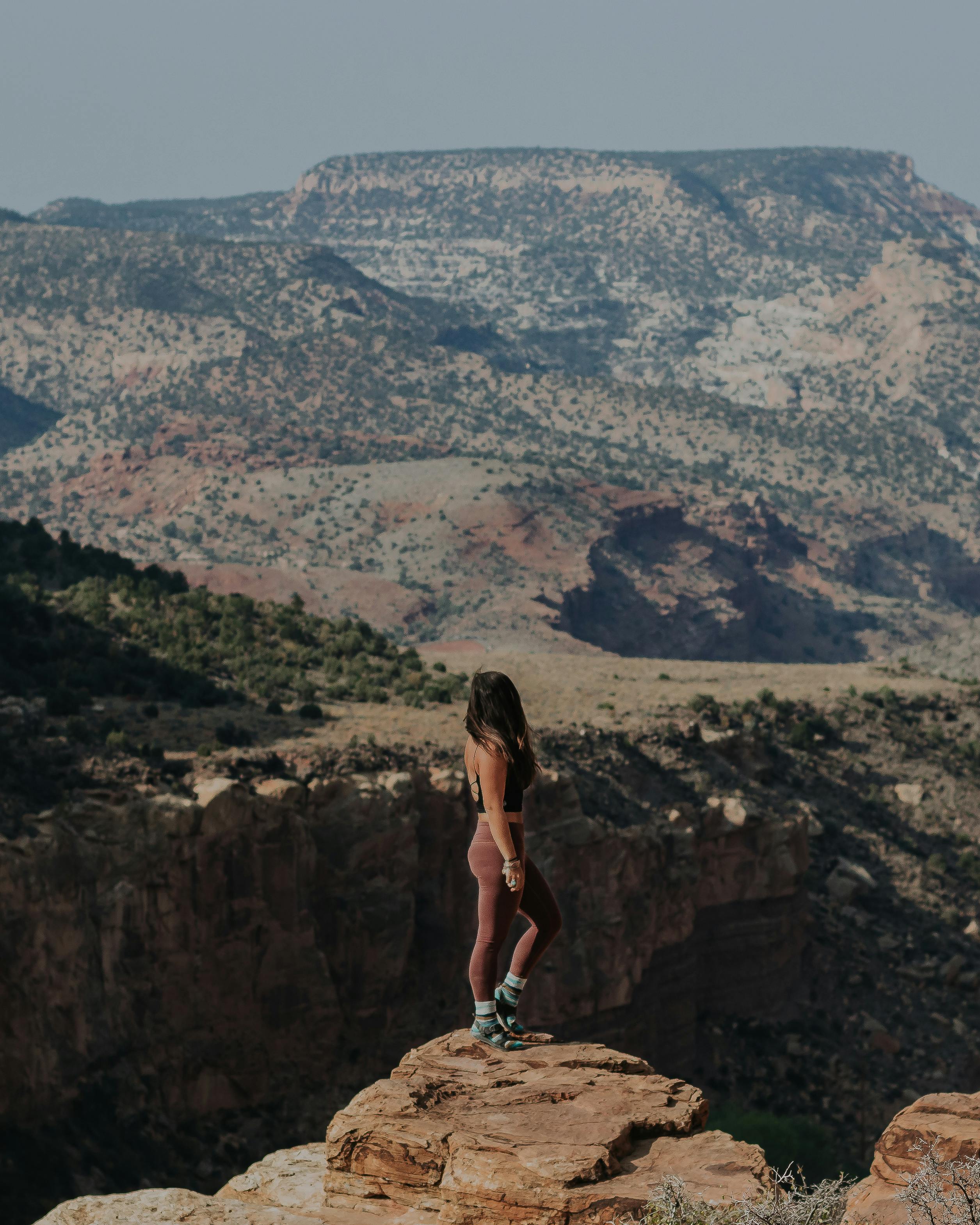 Woman gazing out at canyon views in Oboz hiking shoes in Captiol Reef. National ParkImage credit: Lindsay Kagalis
